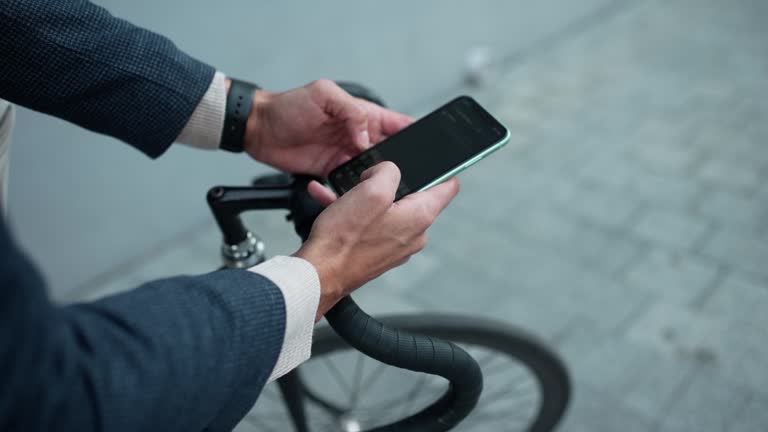 Man texting on mobile while sitting on a bicycle