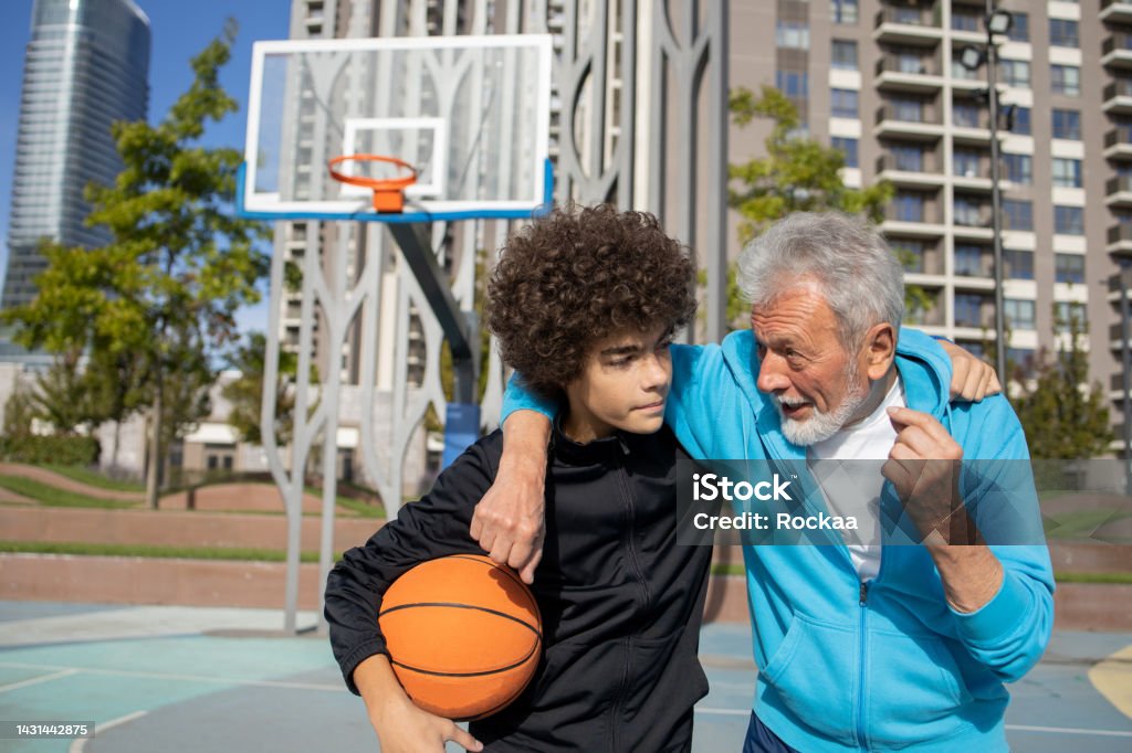 Grandfather and grandson On a basketball court with grandpa Sport Stock Photo