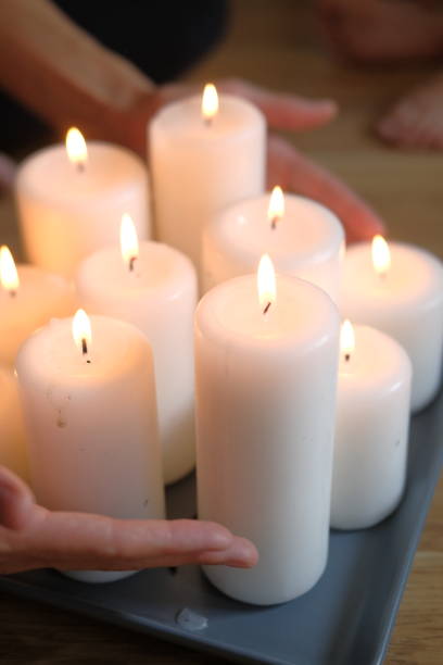 istock Women's hands light candles with matches. Yoga practice and fire in the palms 1431447953
