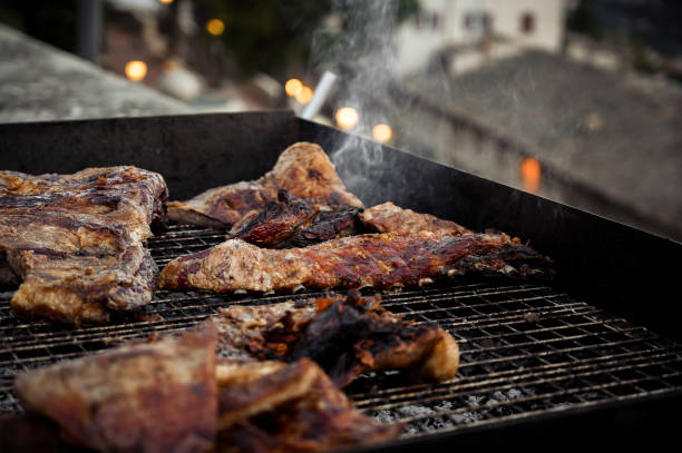Street BBQ with smoke.BBQ food with BBQ ribs grilled meat party summer tasty food roasting.Grilling at summer weekend bbq smoker stock pictures, royalty-free photos & images