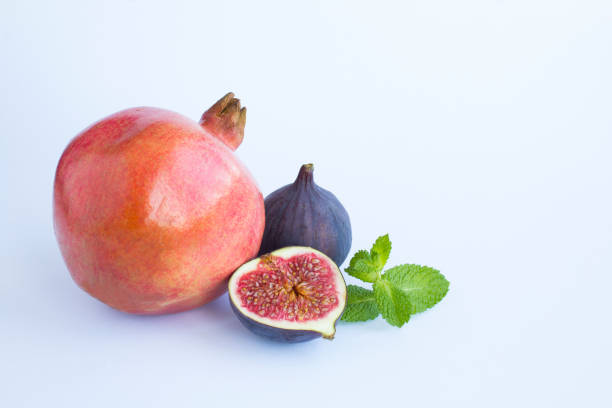 istock Close-up on pomegranate and  blue figs on the white background. Copy space. 1431451437