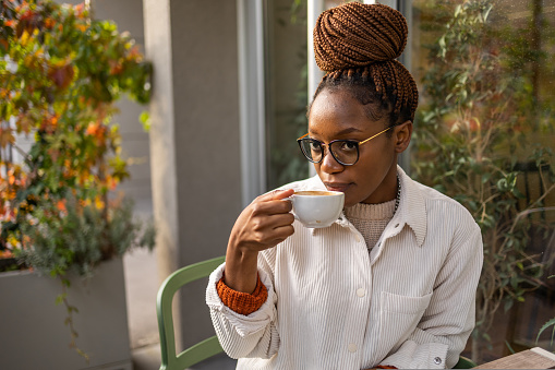 Close up profile of an African American woman drinking a coffee.