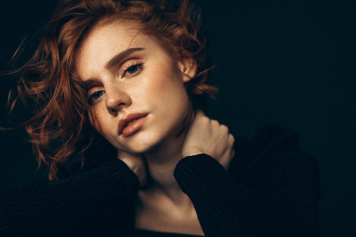 young redhead girl near Lighthouse and blue sea on background