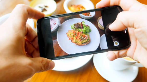 istock Man hands shooting healthy breakfast on wooden table in cafe 1431468074