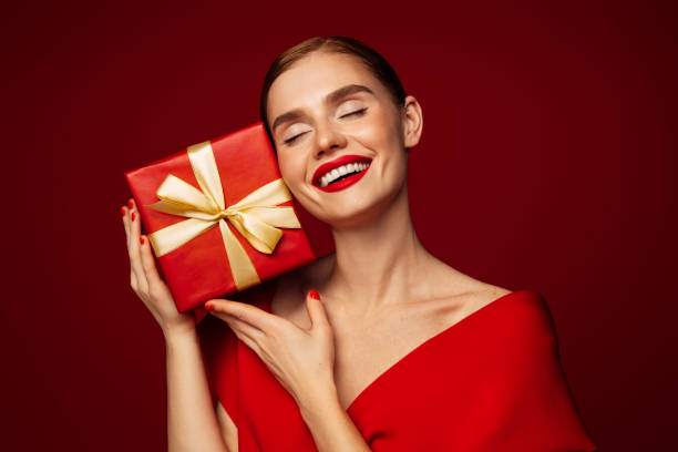 Beautiful emotional woman holding present box