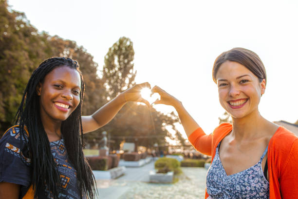 istock Two multiracial female friends making heart shape with their hands at sunset 1431473204