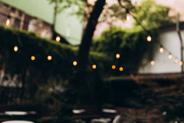 istock Decorative outdoor string lights at night time, Defocused Background, night city life backdrop, party time with Yellow bokeh balls 1431474751