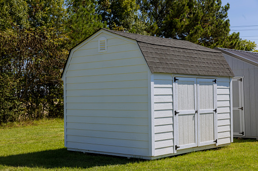 Wooden storage shed for gardening tools in backyard