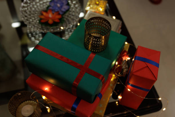 stack of gift boxes on glass table along with candles and sparkling light during Diwali, christmas, new year stock photo
