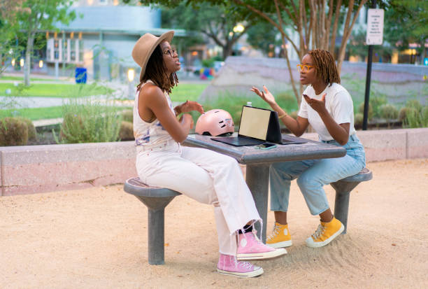 istock Twin sisters working on a public park outdoors instead of the office 1431478153