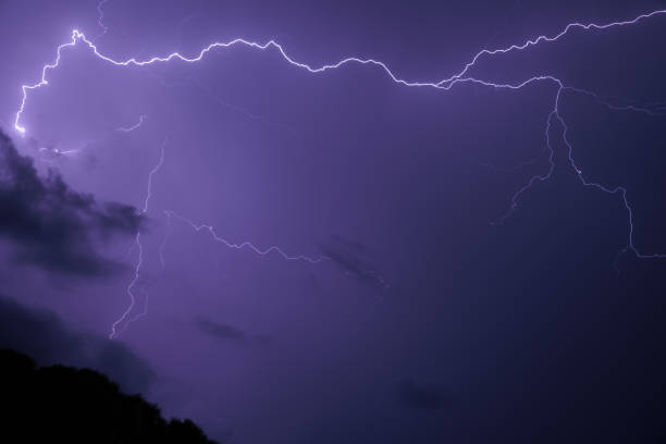 istock Lightnings striking in the dark sky within the clouds at night during a violent storm 1431479807