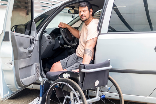 Photo of a man with disability in his car. Wheelchair.