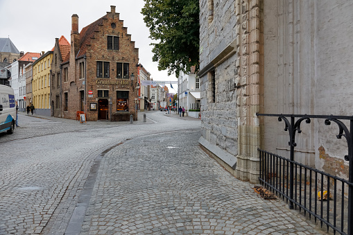 Bruges, Belgium - September 9, 2022: Cobblestone streets junction in the old town. Brick and stone facades can be seen here