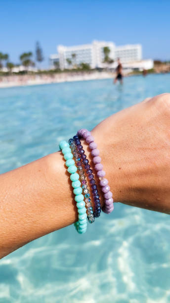 Female hand with bracelets. Sea in background.