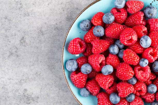 istock Fresh raspberries in a plate on a  vintage background. 1431484791
