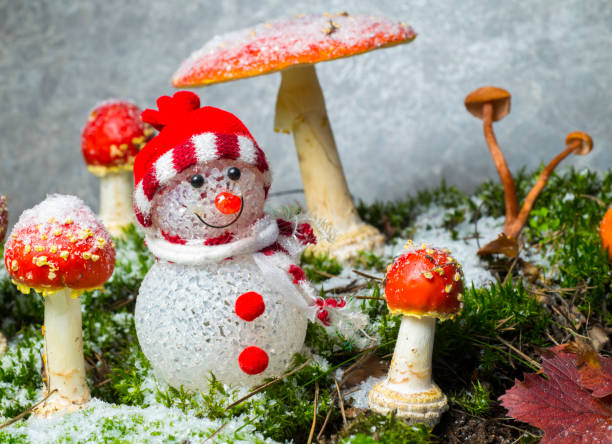 small toy snowman among fly agaric.winter christmas background