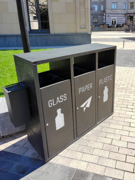 istock Sorting garbage bins on the street, which are divided into GLASS, PAPER and PLASTIC with the corresponding logo 1431499165