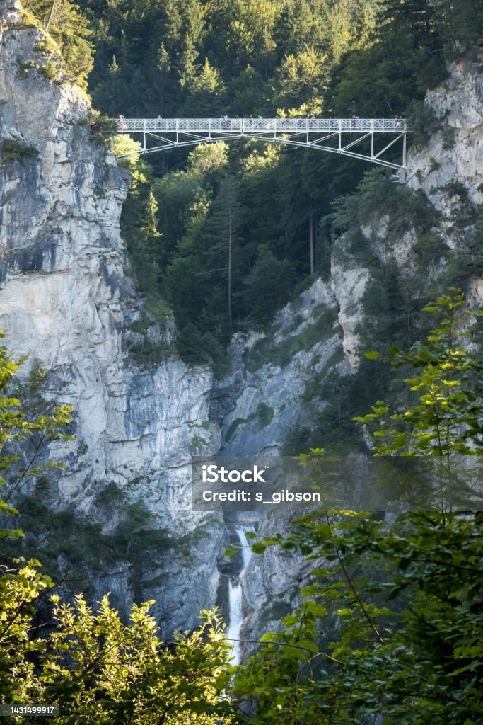 Bridge and Waterfall The Marienbrücke bridge spans a small canyon and waterfall near Neuschwanstein Castle, Schwangau, Bavaria, Germany Adult Stock Photo