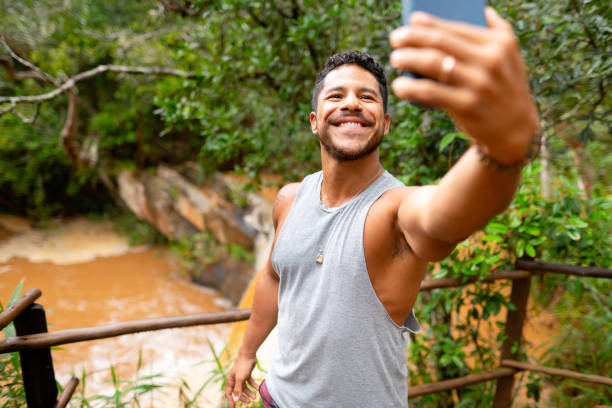 istock Smiling young man taking selfies overlooking a tropical river 1431500729