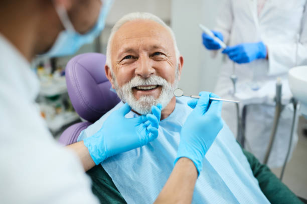 Happy senior man having dental treatment at dentist's office. stock photo