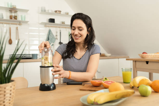 istock Happy young woman making a smoothie for snack 1431512656
