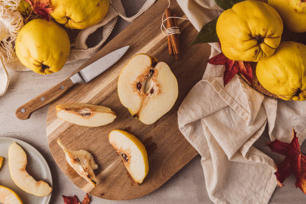 Ripe whole and sliced quinces. Fresh fruit for preparing recipes with cinnamon and lemon. An essential ingredient for a healthy diet