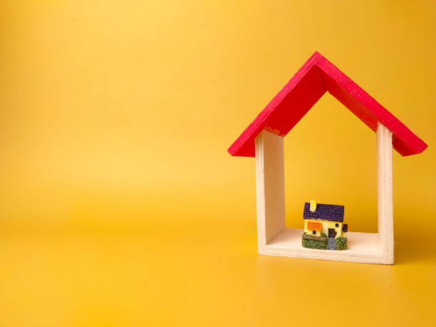 istock Toy house and miniature house isolated on yellow background with copy space 1431521987