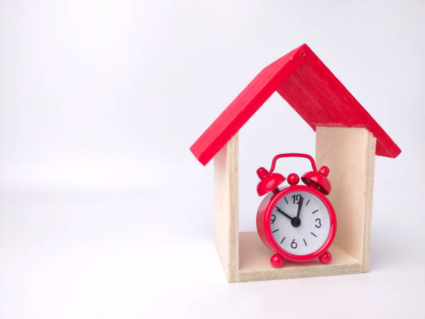 istock Alarm clock and toy house on a white background with copy space. 1431522480