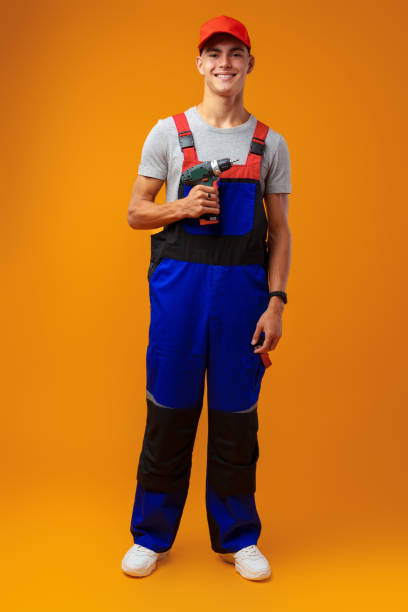 istock Handsome young handyman holding screwdriver against yellow background 1431553015