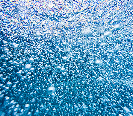 This is a abstract close up underwater photo of a spa jets for water massage with all the bubble coming directly towards the camera