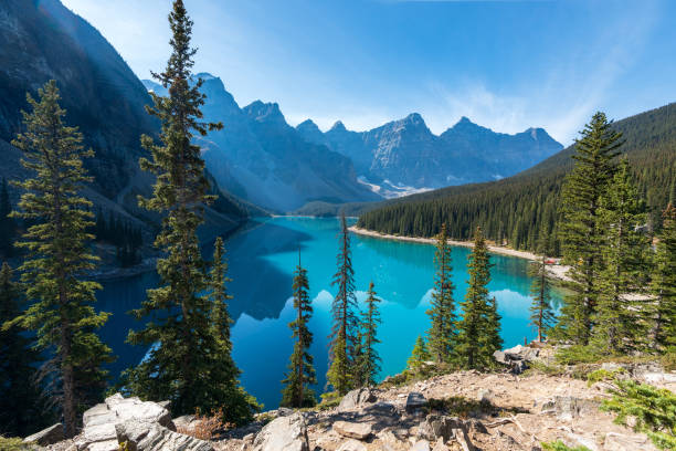 Moraine lake beautiful landscape in summer sunny day morning. Shadow moves on turquoise blue water with reflection. Canadian Rockies. Banff National Park. stock photo