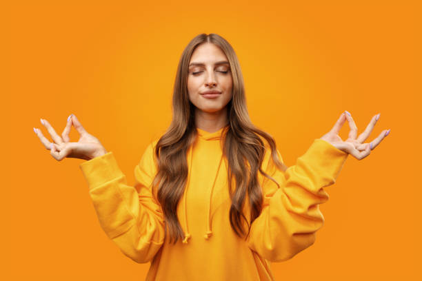 istock Young blonde woman making zen pose while meditating on yellow background 1431556008