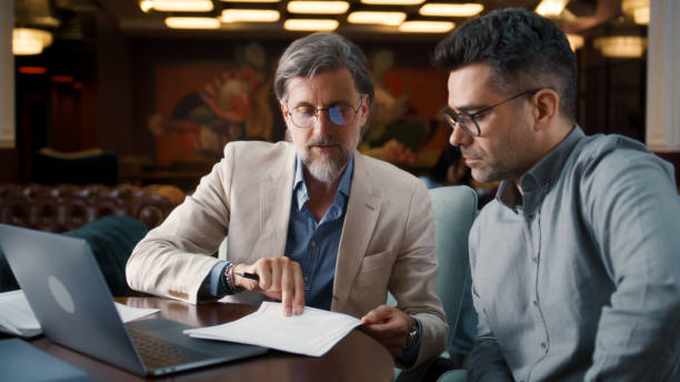 istock Mature man showing contract to businessman 1431560162