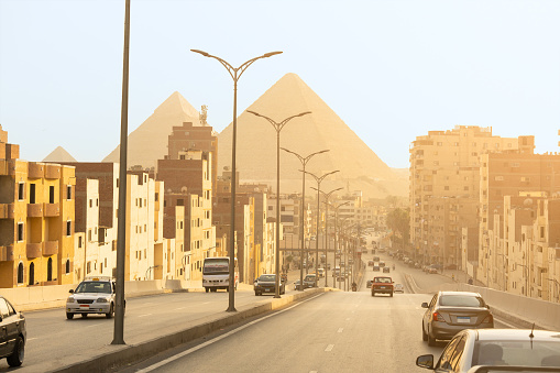 Cairo street with the pyramids of Giza in the background of the photo