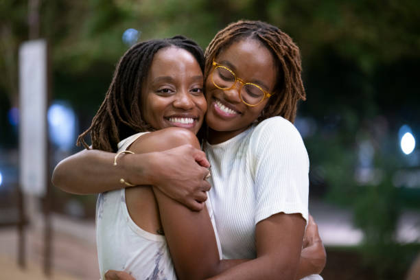 istock Twin sisters hugging and laughing outdoors 1431576246