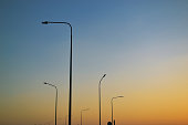 Tall lampposts against the background of a gradient evening clear sky