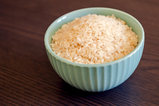 small blue bowl close up with raw white rice