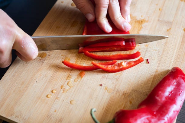 istock man hands cutting red pepper close up on wooden board 1431584531
