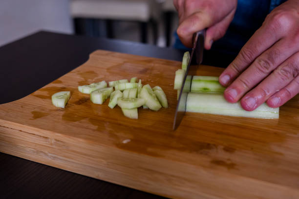 istock man hands cutting fresh cucumber close up 1431584634