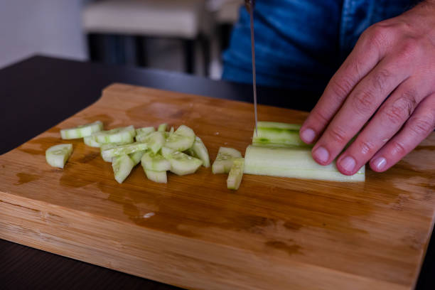istock man hands cutting fresh cucumber close up 1431584636