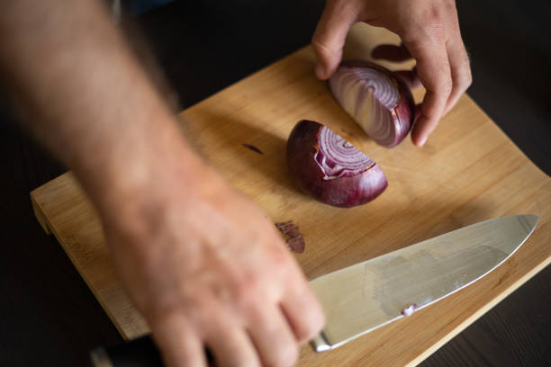 istock man hands cutting red onion close up on wooden board 1431584750