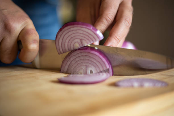 istock man hands cutting red onion close up on wooden board 1431584754
