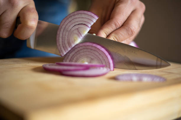 istock man hands cutting red onion close up on wooden board 1431584760