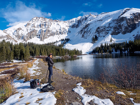 A woman tourist taking pictures of Alta Lakes in springtime, San Juan National Forest, Colorado