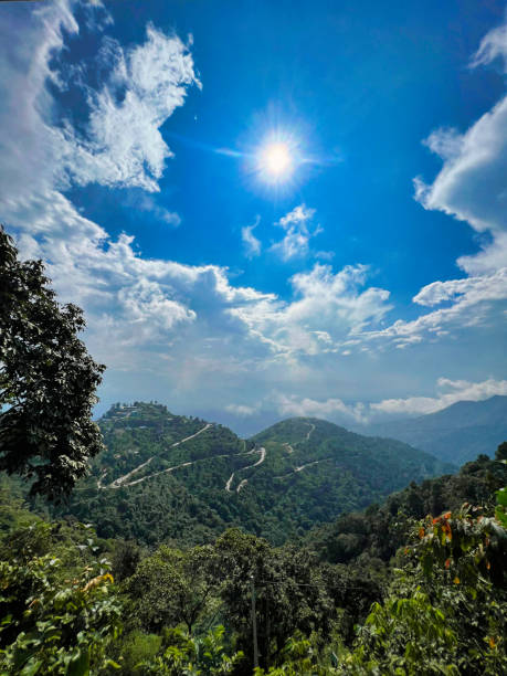 Blue cloudy sky and massive hills and huge forest