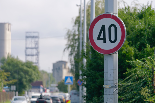 Selective focus shot of a Maximum Speed Limit 40 Street Sign with a street in the background