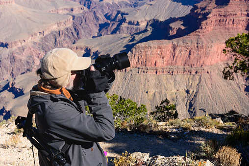 A man tourist taking pictures of Grand Canyon National Park