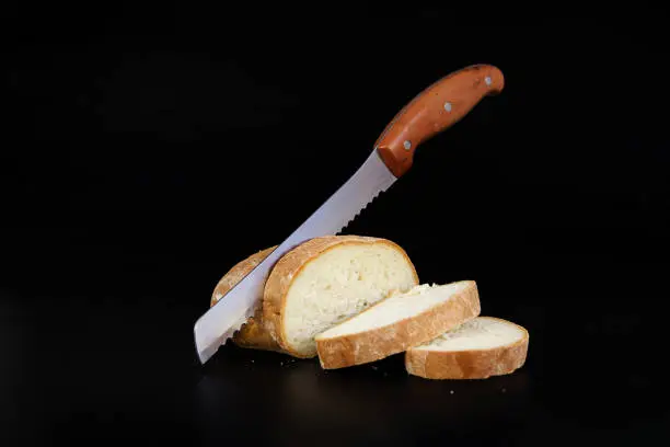 Bread Knife Slicing Through a Loaf. Seed bread, homemade bread,cutting bread