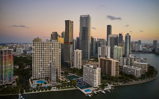 Elevated drone view over Biscayne Bay of marina, hotels, residential buildings, and Miami in background.