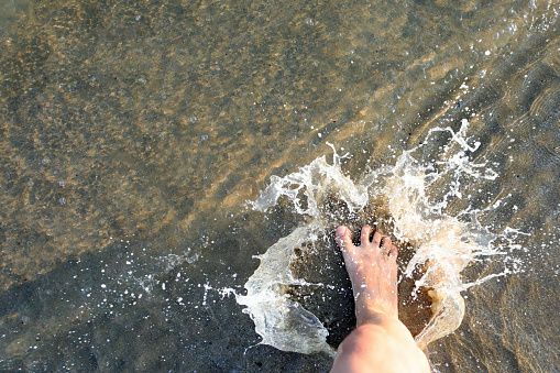 splashes of sea water and the foot of the person who stepped on it